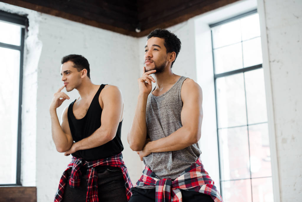 zamyšlení multikulturní muži dotýkající se tváří v tanečním studiu  - Fotografie, Obrázek
