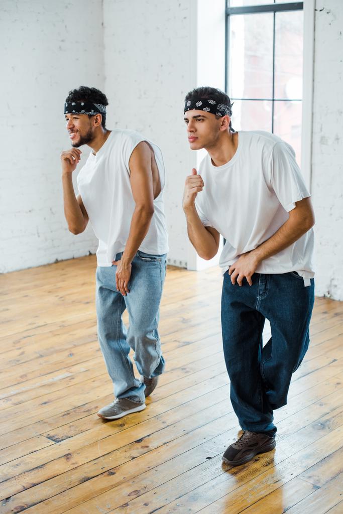 dançarinos multiculturais bonitos em headbands dançando hip-hop
 - Foto, Imagem