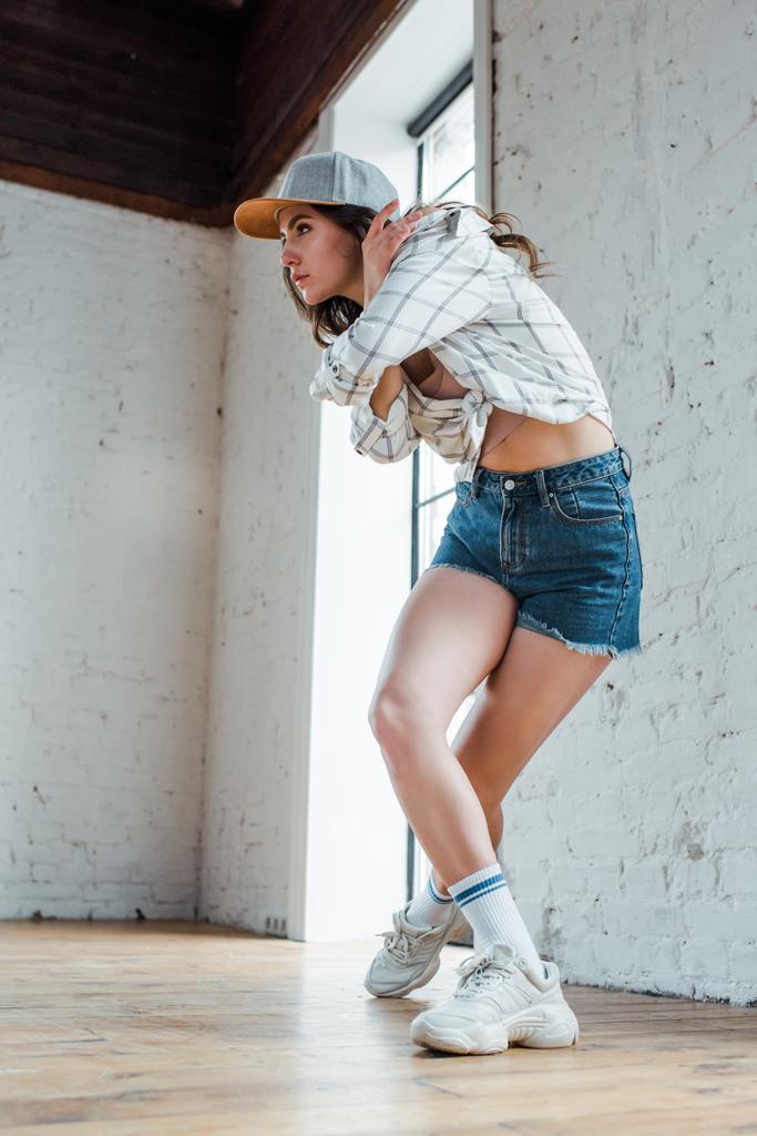 Hip-hop dansı yaparken şapkalı çekici dansçı  - Fotoğraf, Görsel