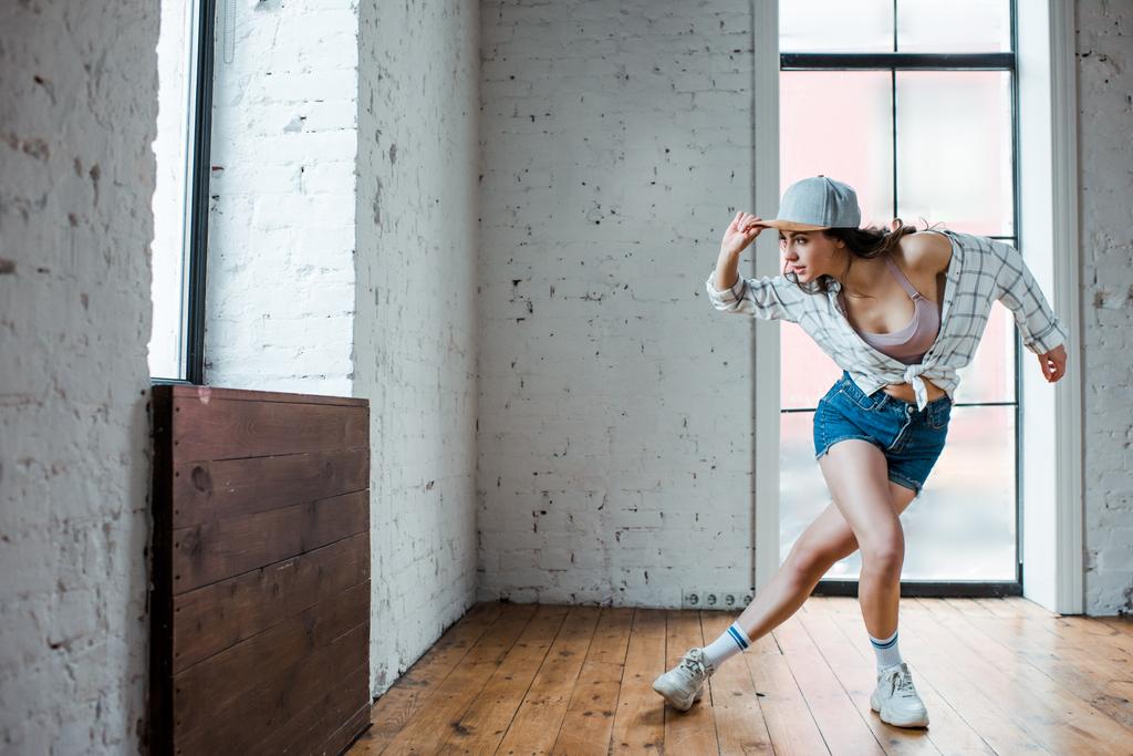 jovem mulher tocando cap e dançando hip-hop
  - Foto, Imagem