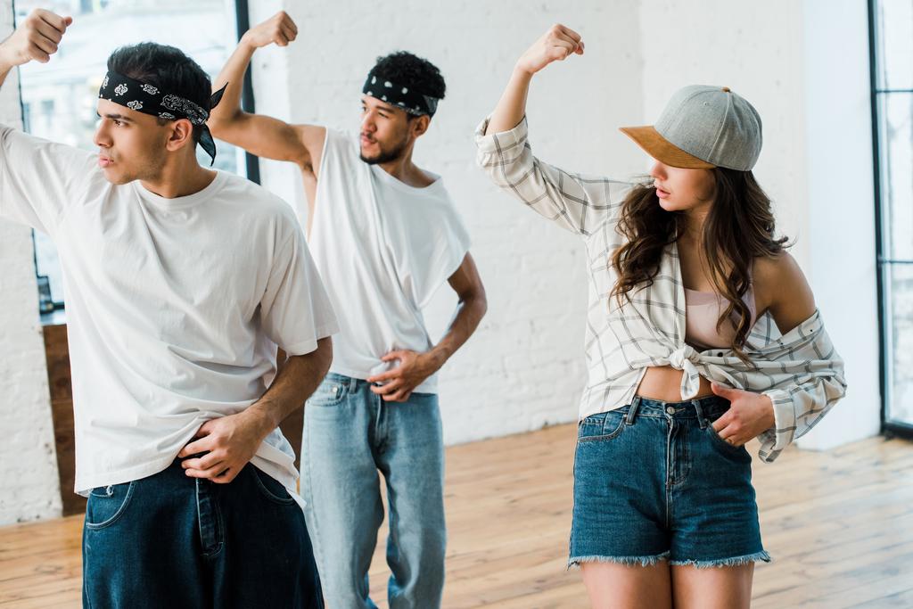 selective focus of multicultural dancers gesturing while dancing hip-hop in dance studio  - Fotoğraf, Görsel