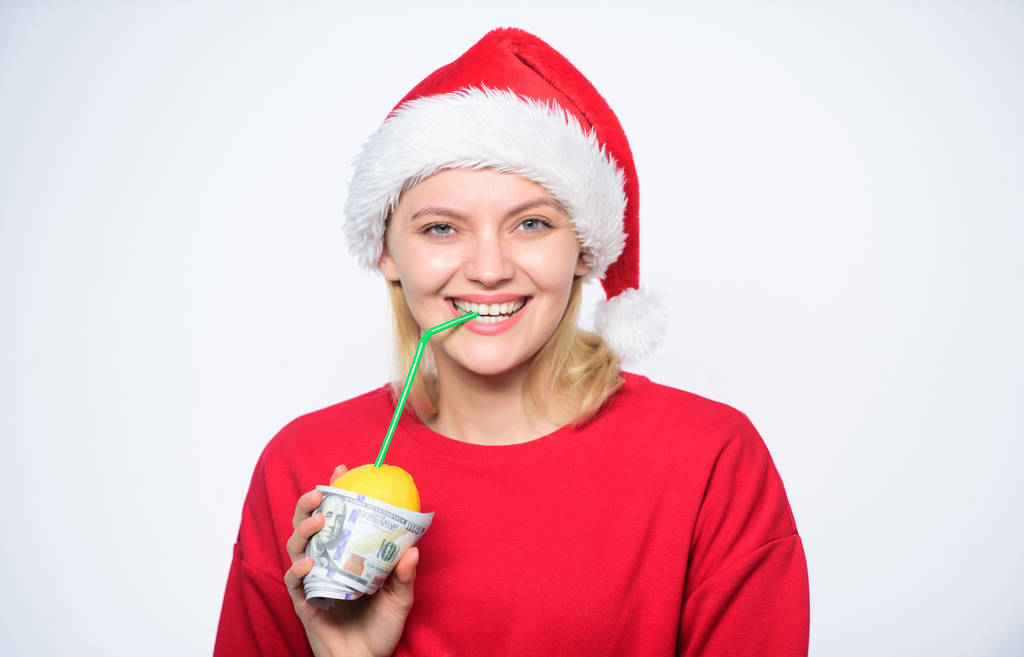 Fresh lemonade drink with straw. Symbol of wealth and richness. Christmas lemonade punch. Girl santa hat drink juice lemon wrapped in banknote. Totally natural lemonade. Girl with lemonade and money - Photo, Image
