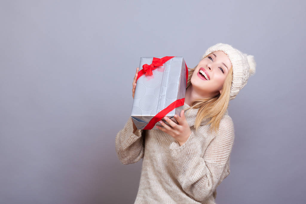 Retrato de una joven sonriente sosteniendo un regalo en sus manos
 - Foto, imagen