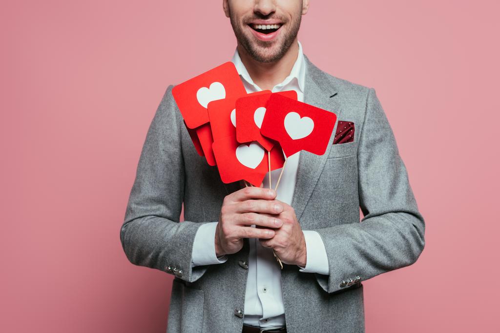 abgeschnittene Ansicht eines Mannes, der Karten mit Herzen für den Valentinstag hält, isoliert auf rosa  - Foto, Bild