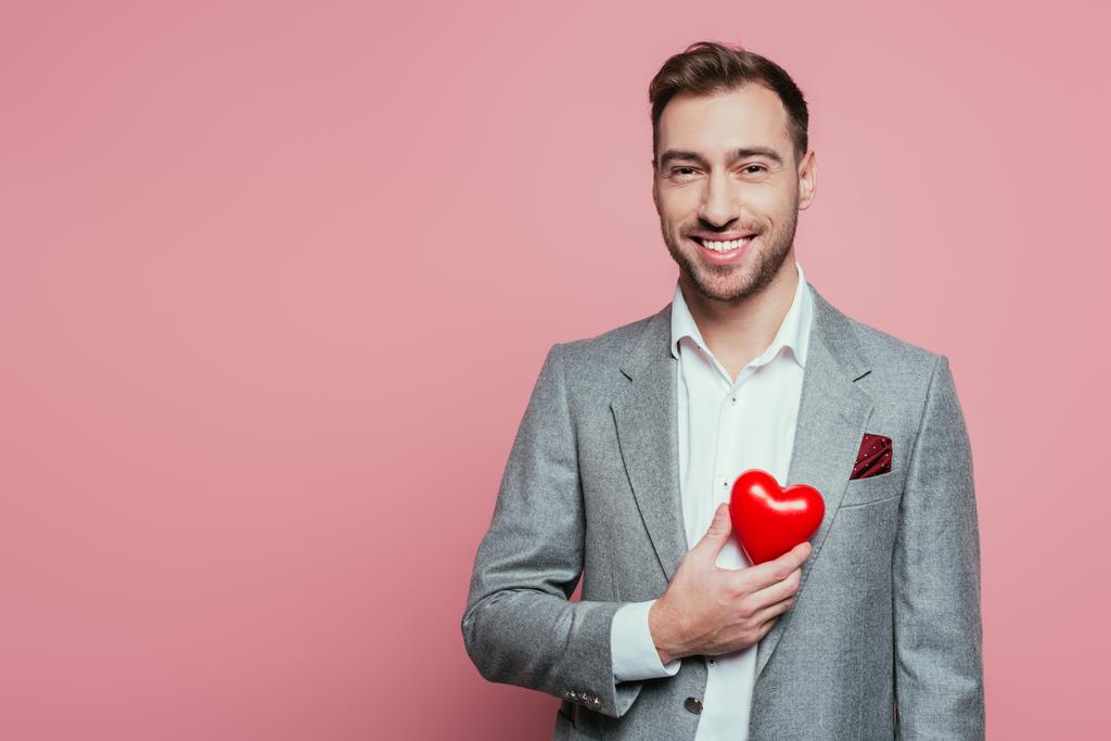 šťastný muž drží červené srdce na Valentýna, izolované na růžové  - Fotografie, Obrázek