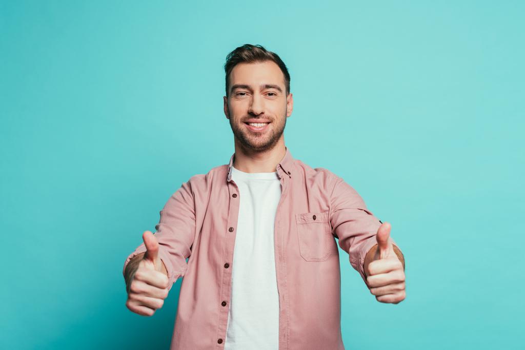 smiling handsome man showing thumbs up, isolated on blue - Photo, Image