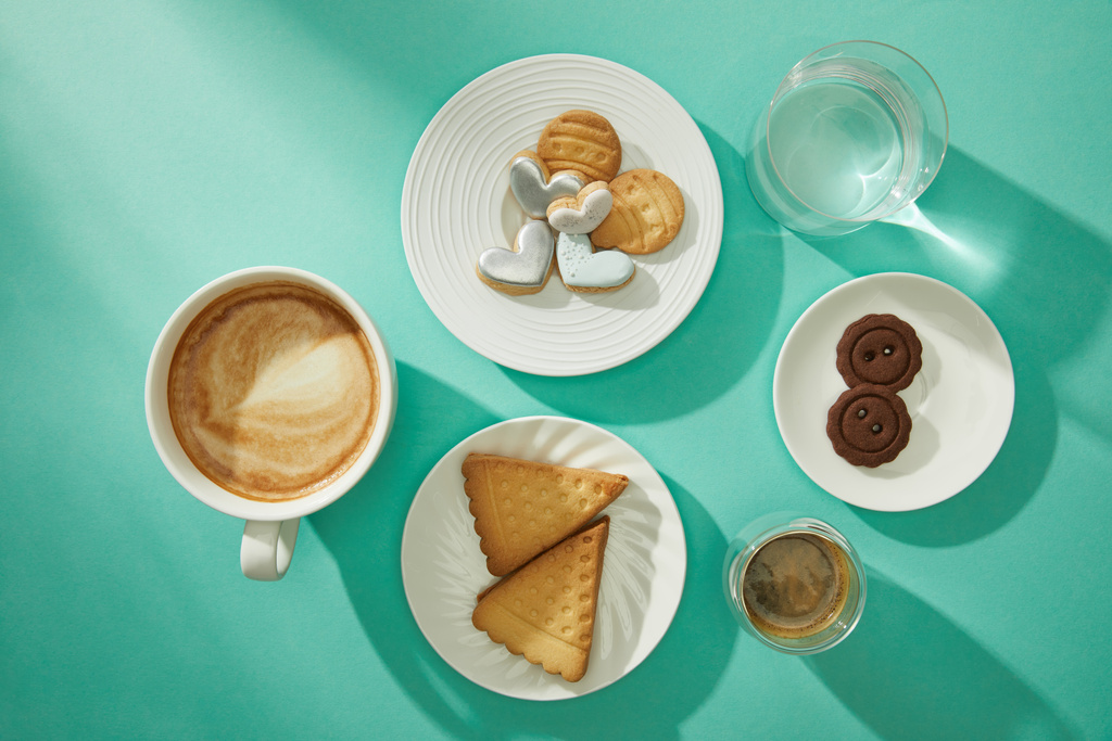 Вид сверху на свежие блюда с кофе и стаканом воды на бирюзовом фоне
 - Фото, изображение