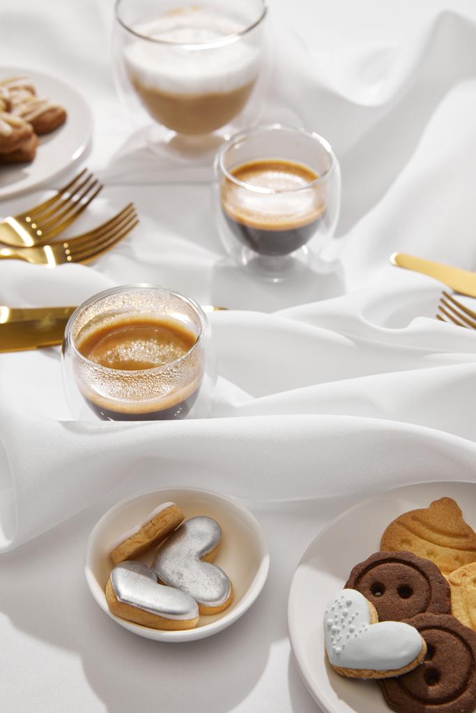 Вибірковий фокус свіжої кави з смачним печивом на білій хвилястій тканині
 - Фото, зображення