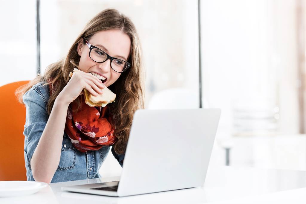 Πορτρέτο της Νέας ελκυστική επιχειρηματίας τρώει σάντουιτς στο γραφείο της στο γραφείο - Φωτογραφία, εικόνα