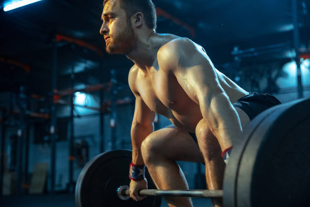 Hombre caucásico practicando levantamiento de pesas en gimnasio
 - Foto, imagen