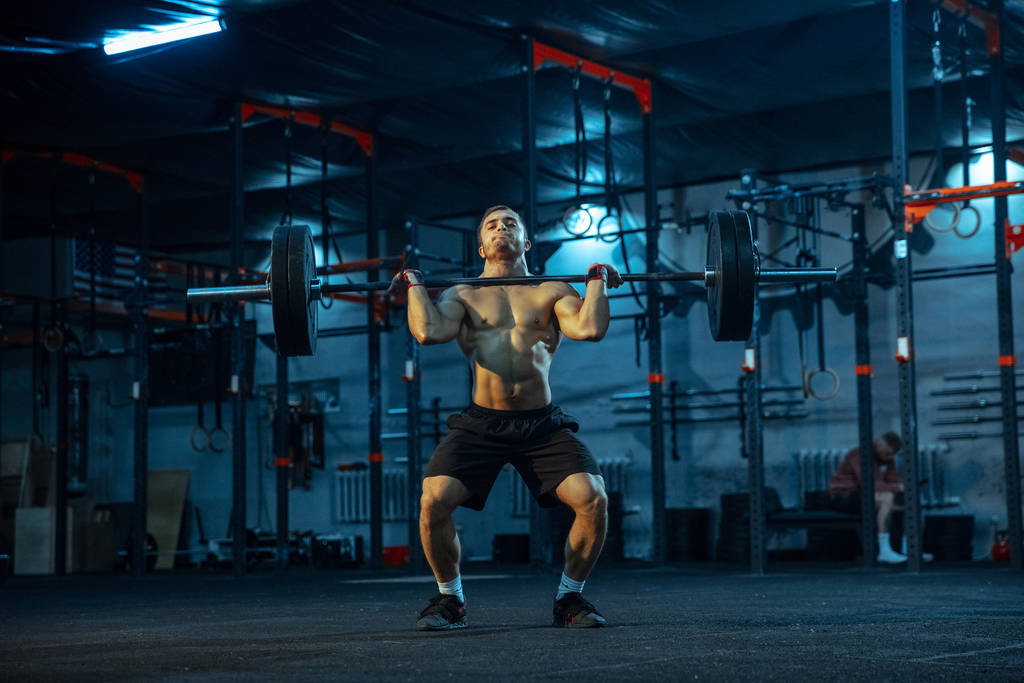 Caucasian man practicing in weightlifting in gym - Photo, Image