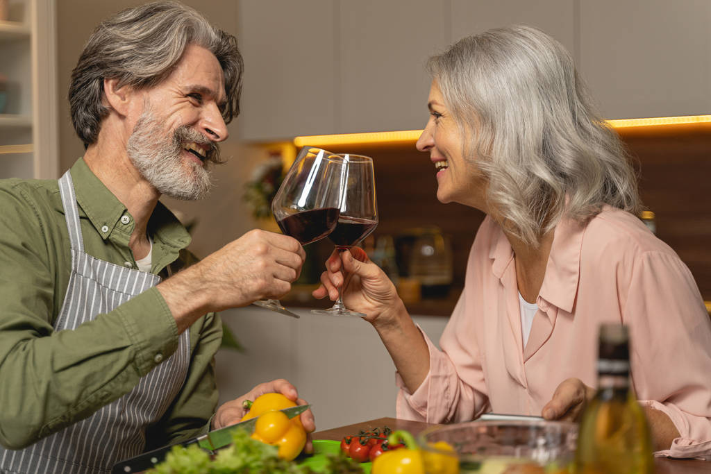 Casal casal bebendo vinho tinto na cozinha
 - Foto, Imagem