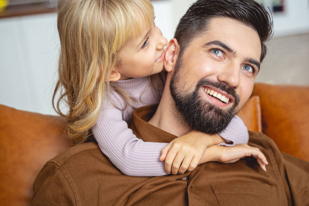 Cute little girl whispering something to father ear - Photo, Image