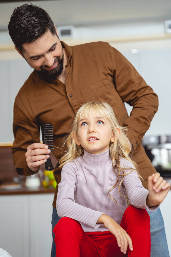 Χαρούμενος πατέρας βουρτσίζει τα μαλλιά της κόρης του - Φωτογραφία, εικόνα