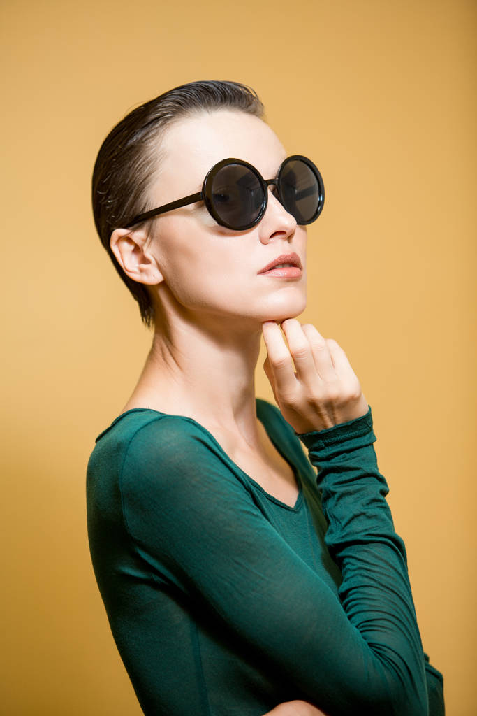 Portret młodej kobiety w okularach przeciwsłonecznych na żółtym tle - Zdjęcie, obraz