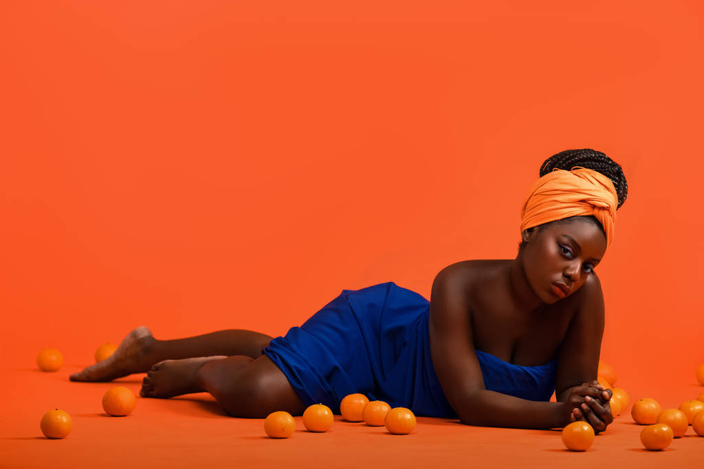 Молодая африканская модель с красивым макияжем в студии на ярком фоне
 - Фото, изображение