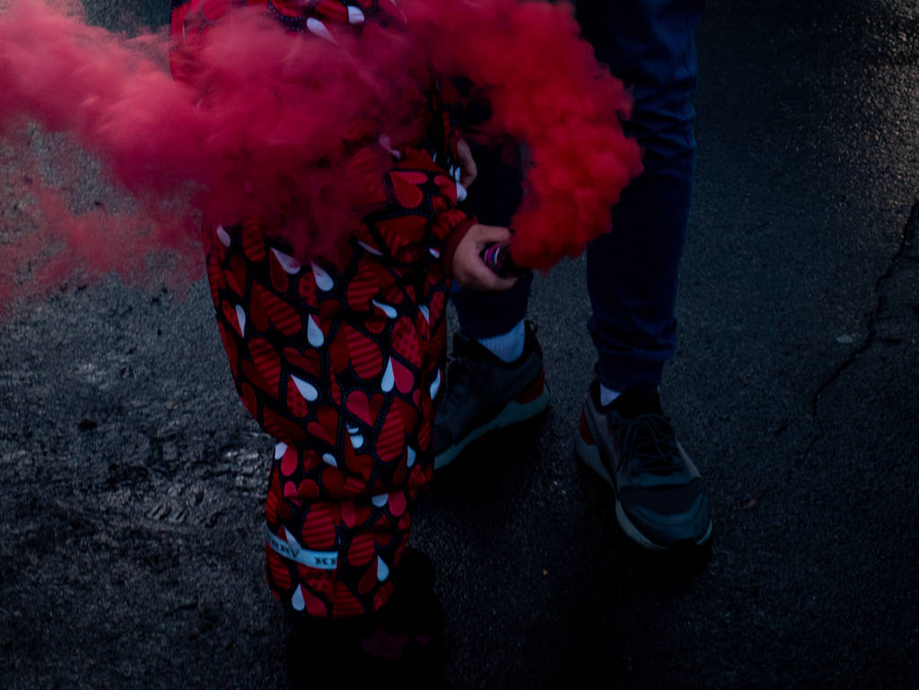 A gyerek füstbombát használ. Élénk vörös..  - Fotó, kép