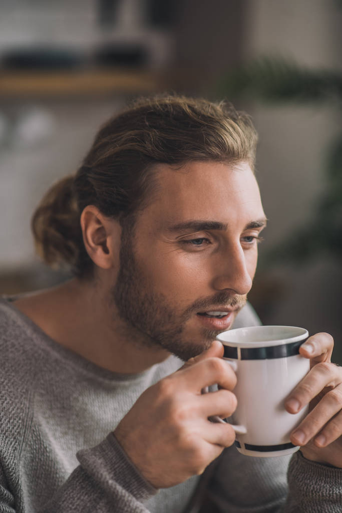 Jeune homme beau barbu en gris profitant de son café
 - Photo, image