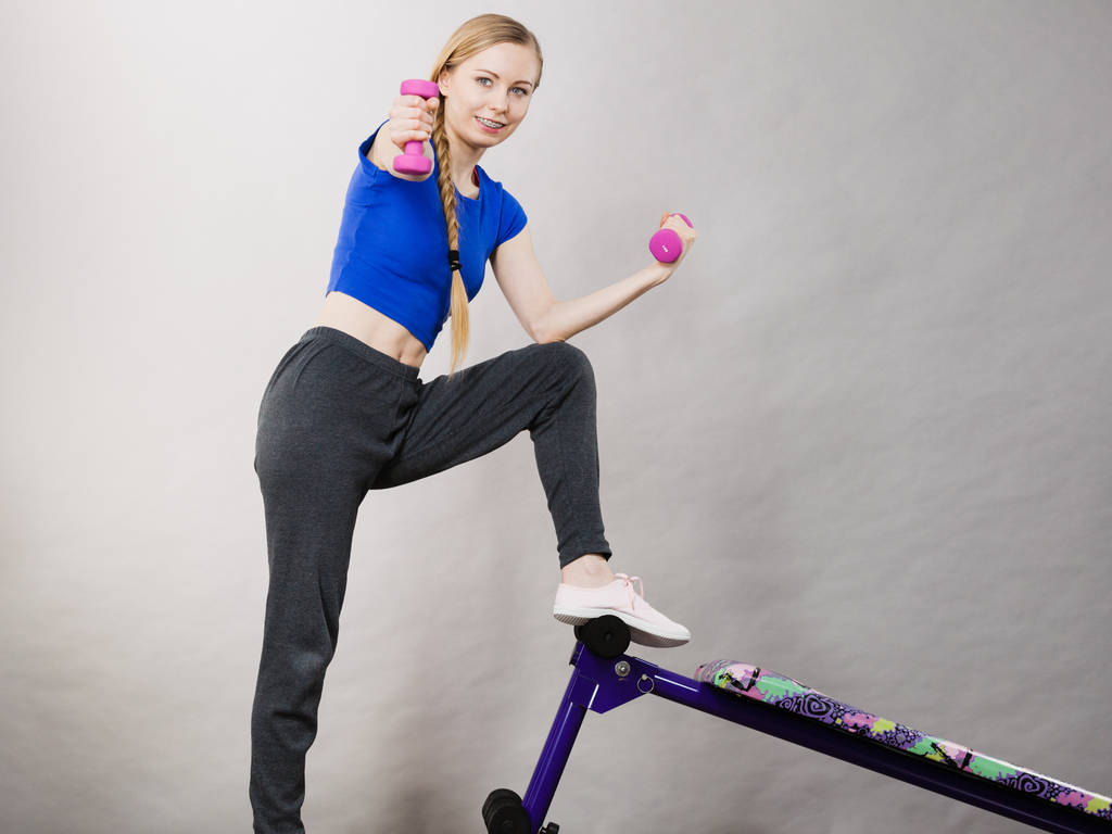 Teenage woman working out at home with dumbbell - Photo, Image