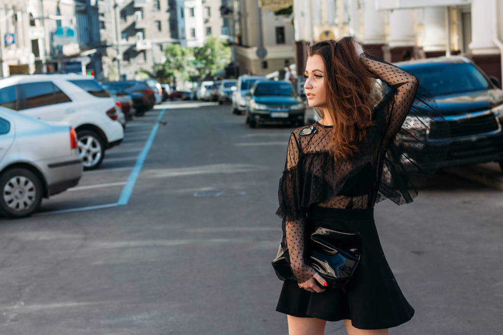 πορτρέτο κοριτσιού, μελαχρινής, με μαύρο φόρεμα, στην αψίδα, στην πόλη. Ποζάρουν, περπατούν. μόνος στο πλήθος, μοναξιά - Φωτογραφία, εικόνα