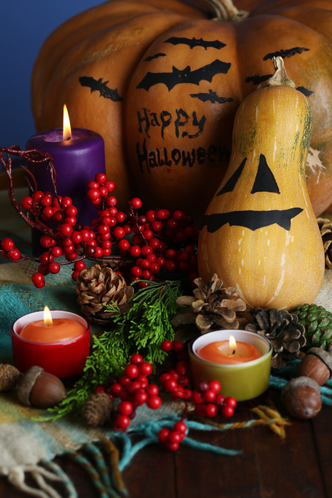 Composition for Halloween with pumpkins and candles on color background - Photo, Image