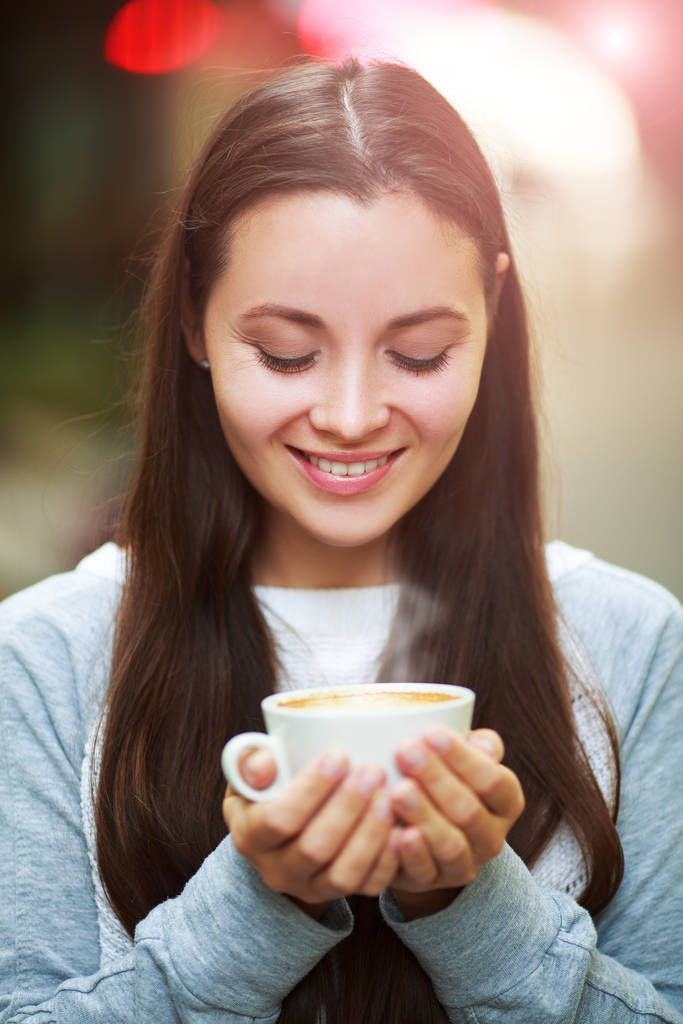 Close up of a woman hands holding a hot coffee cup outside with outdoors in the background. - Photo, Image
