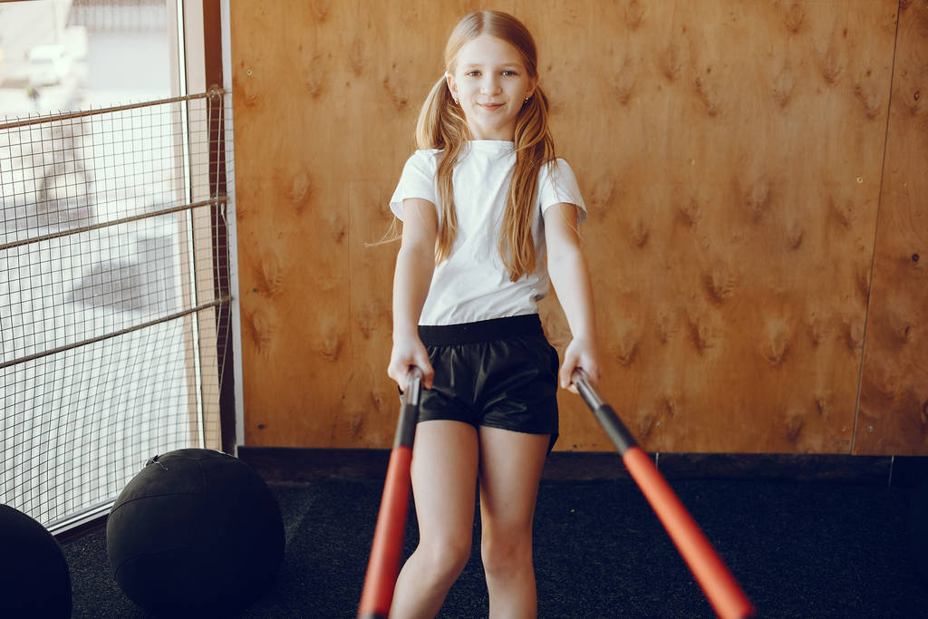 Красивая маленькая девочка занимается в спортзале
 - Фото, изображение