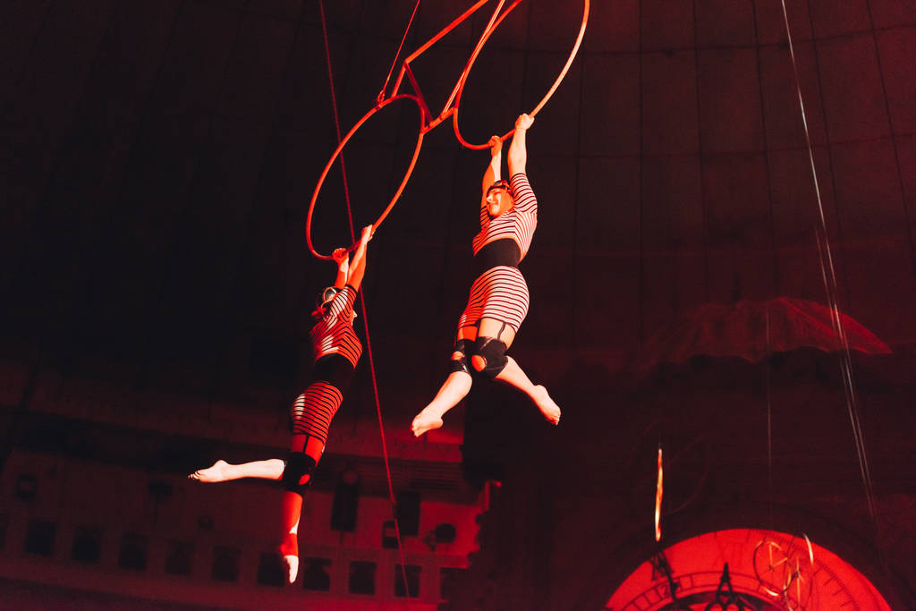 KYIV, UCRÂNIA - NOVEMBRO 1, 2019: Vista de baixo ângulo dos acrobatas aéreos que se apresentam com anéis no circo
  - Foto, Imagem