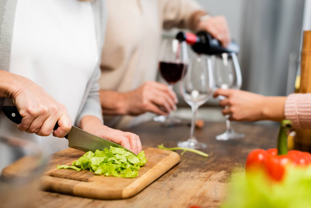 cropped view of woman cutting green lettuce on cutting board  - Photo, Image