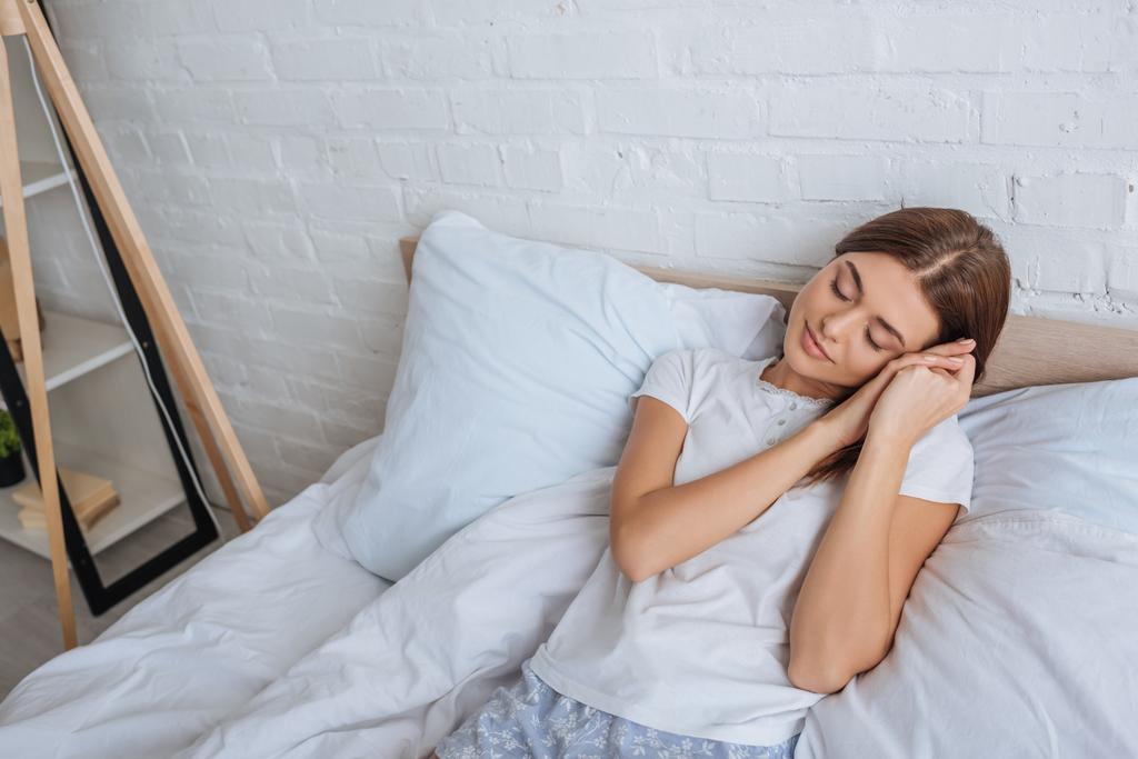 attraktive Frau träumt, während sie zu Hause im Bett liegt  - Foto, Bild