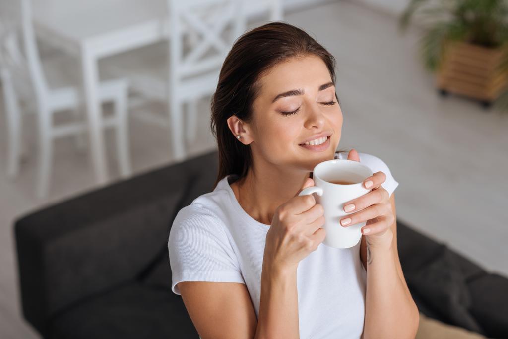 mujer feliz soñando y oliendo taza de té
  - Foto, Imagen