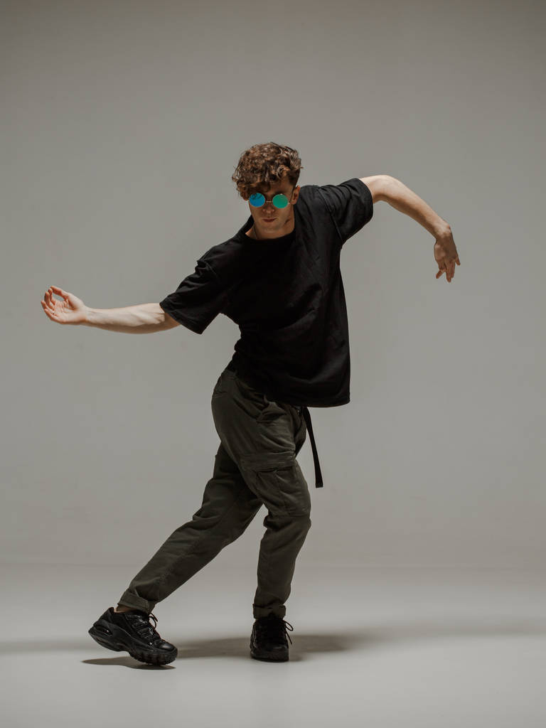 Guy che balla danza contemporanea in studio. Fondo grigio neutro. ballerino bboy acrobatico
. - Foto, immagini