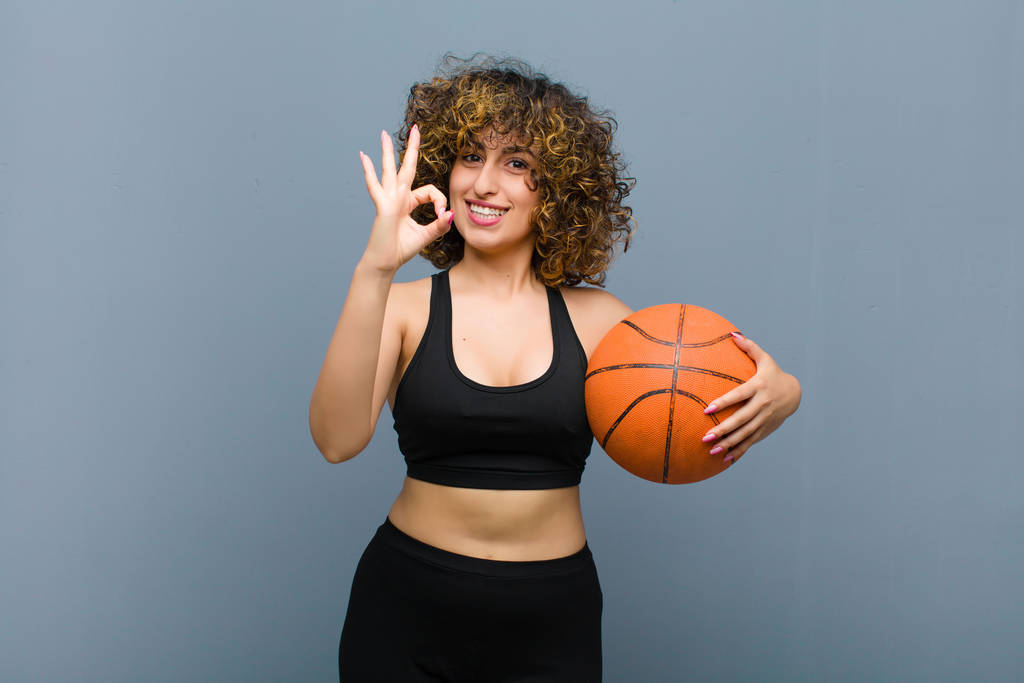 молодая красивая спортивная женщина в спортивной одежде с баскетбольным мячом
 - Фото, изображение