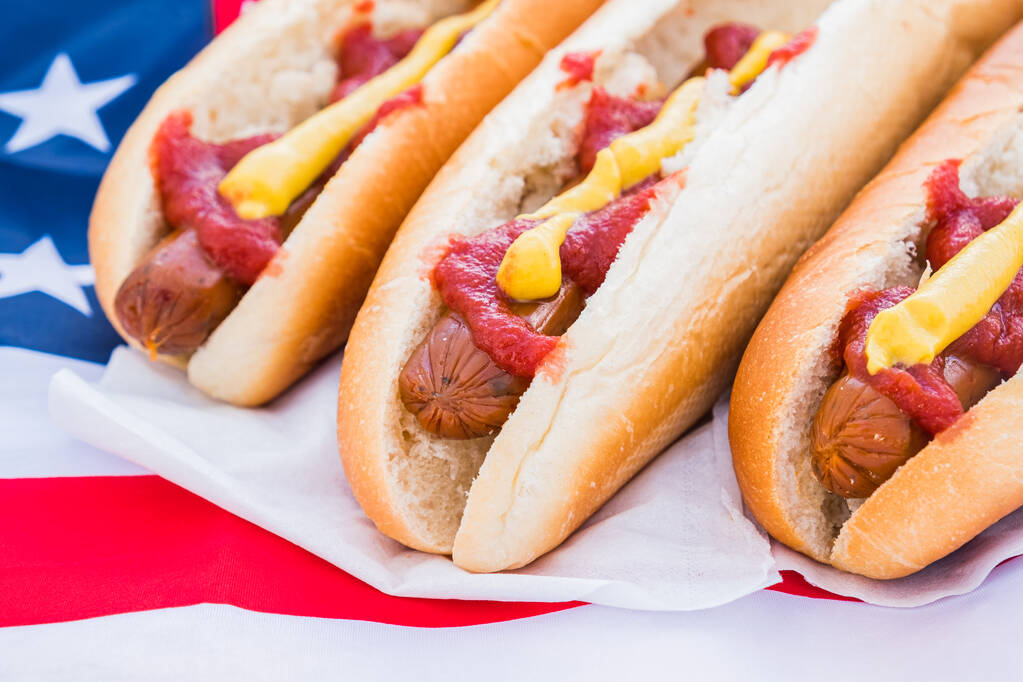 Perros calientes con ketchup y mostaza, vista de cerca. Concepto americano de comida rápida: perros calientes servidos y listos para comer
 - Foto, imagen