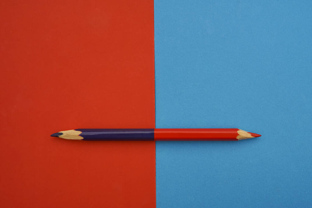 yksi iso kynä, jossa on kaksi - punainen ja sininen - väriä. punainen ja sininen paperi tausta
.  - Valokuva, kuva