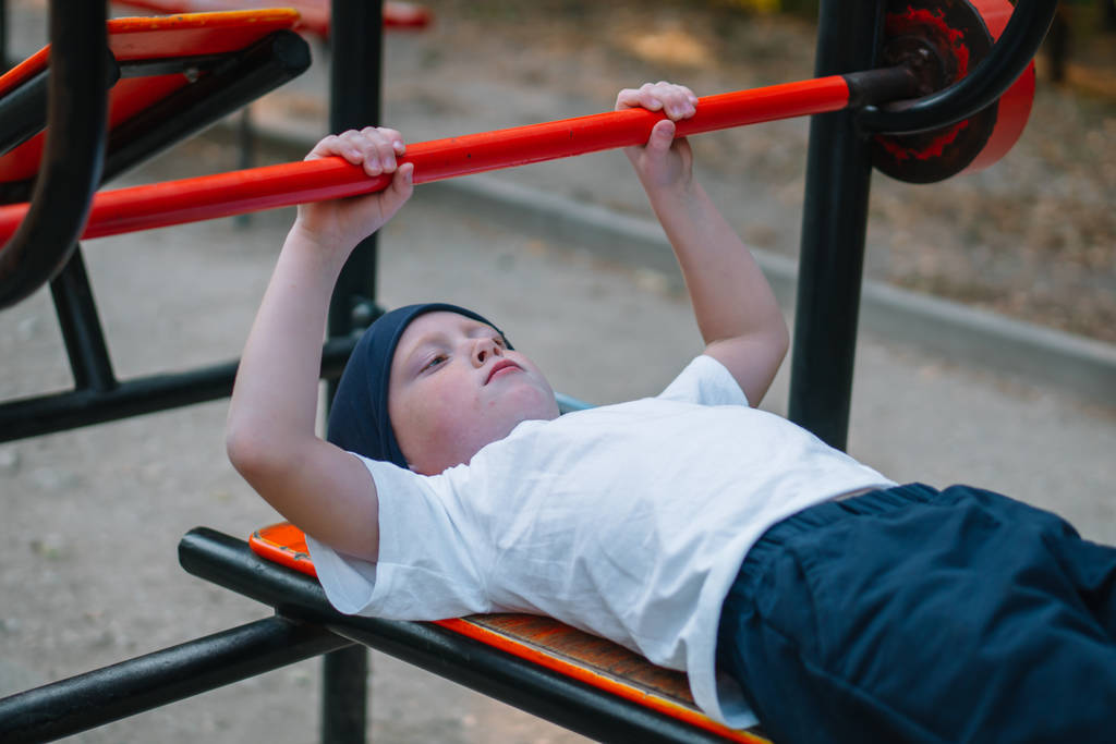 Malý chlapec hraje sporty na ulici veřejné sportovní simulátory - Fotografie, Obrázek