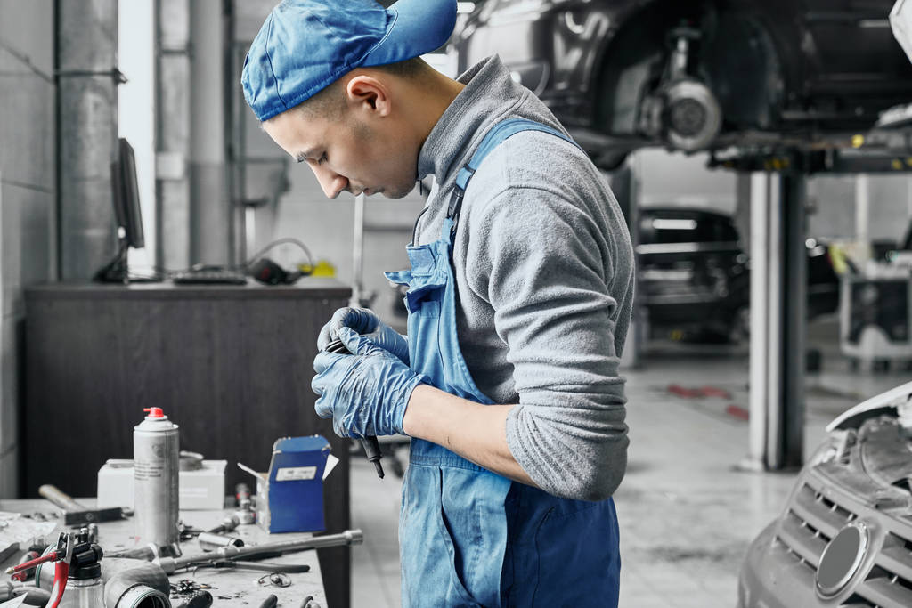 Auto mechanic working near table with different tools - Photo, Image