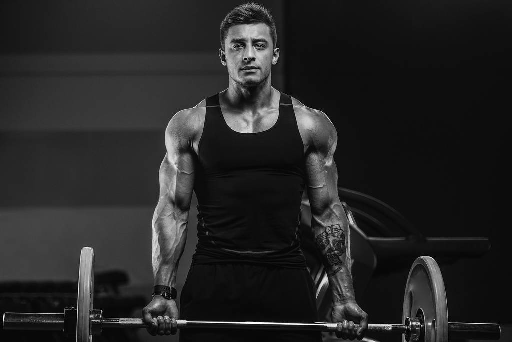 ハンサムな強い運動選手の筋肉のトレーニングをポンプアップ - 写真・画像