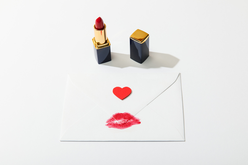 唇のプリントと心臓が白い背景に赤い口紅の近くに封筒 - 写真・画像