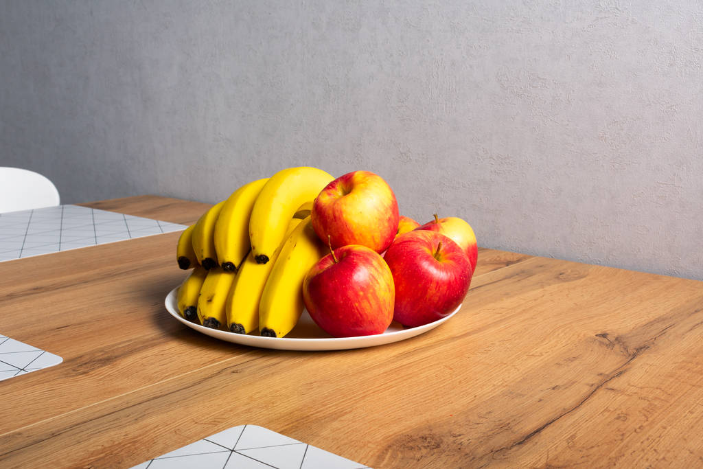 detailní pohled na čerstvě zralá jablka a banány na dřevěném stole  - Fotografie, Obrázek
