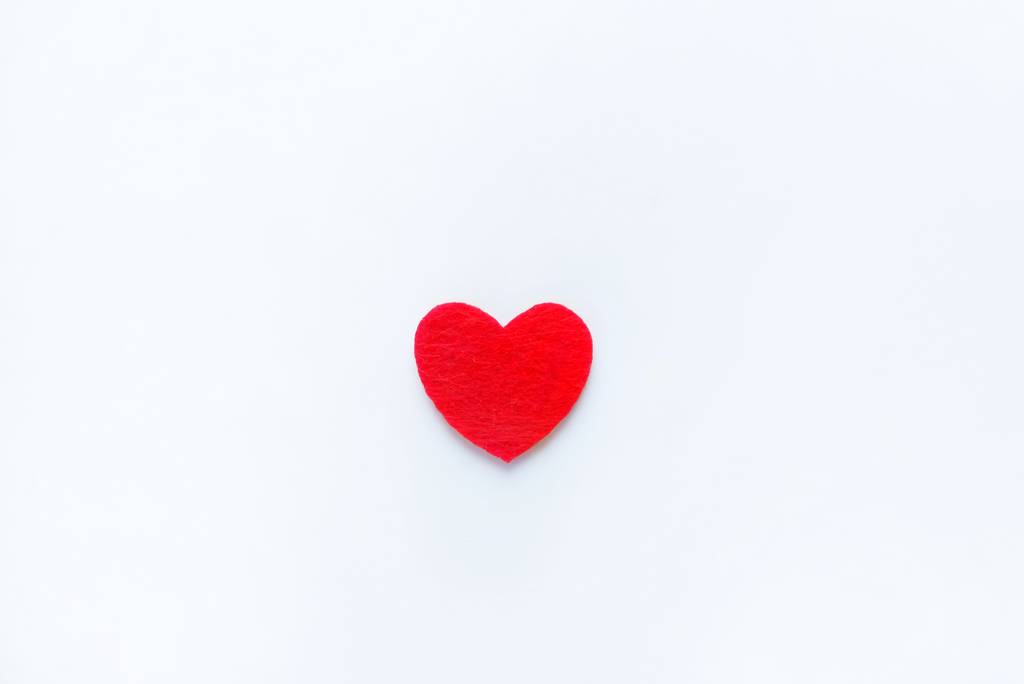 Червоне серце з фетру на білому тлі. Символ дня Святого Валентина, концепція свята, мінімальний стиль. Вид зверху з пробілом для копіювання тексту
. - Фото, зображення