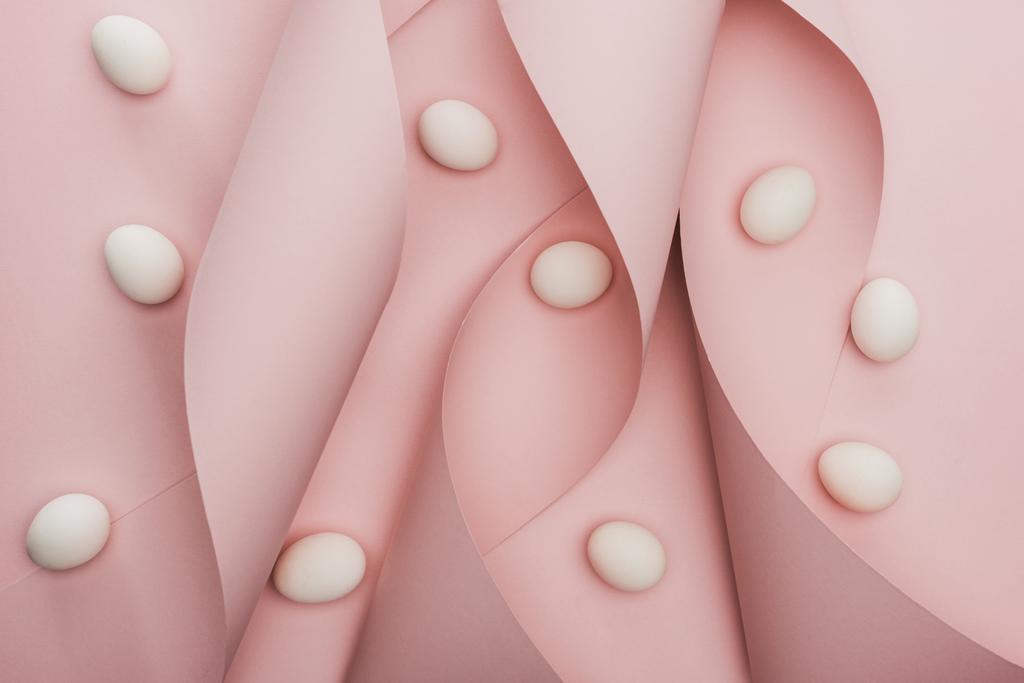 vue du dessus des œufs de poulet en spirale en papier tourbillons roses
  - Photo, image