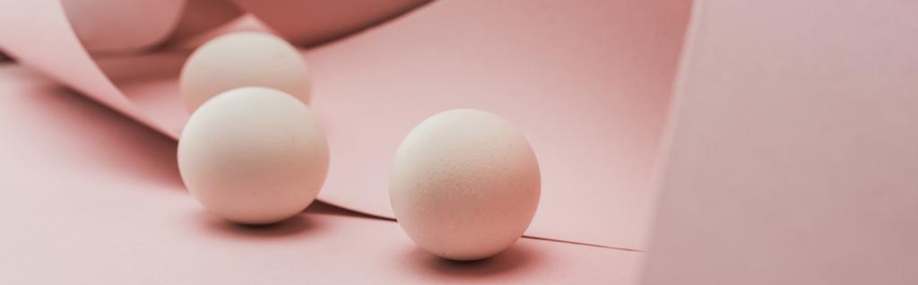 ovos de galinha em espiral de papel redemoinhos cor-de-rosa, tiro panorâmico
 - Foto, Imagem