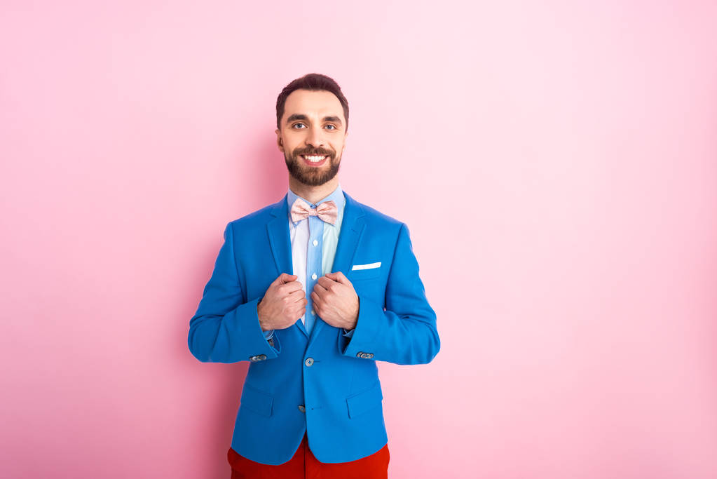 happy bearded businessman smiling while standing on pink  - Photo, Image