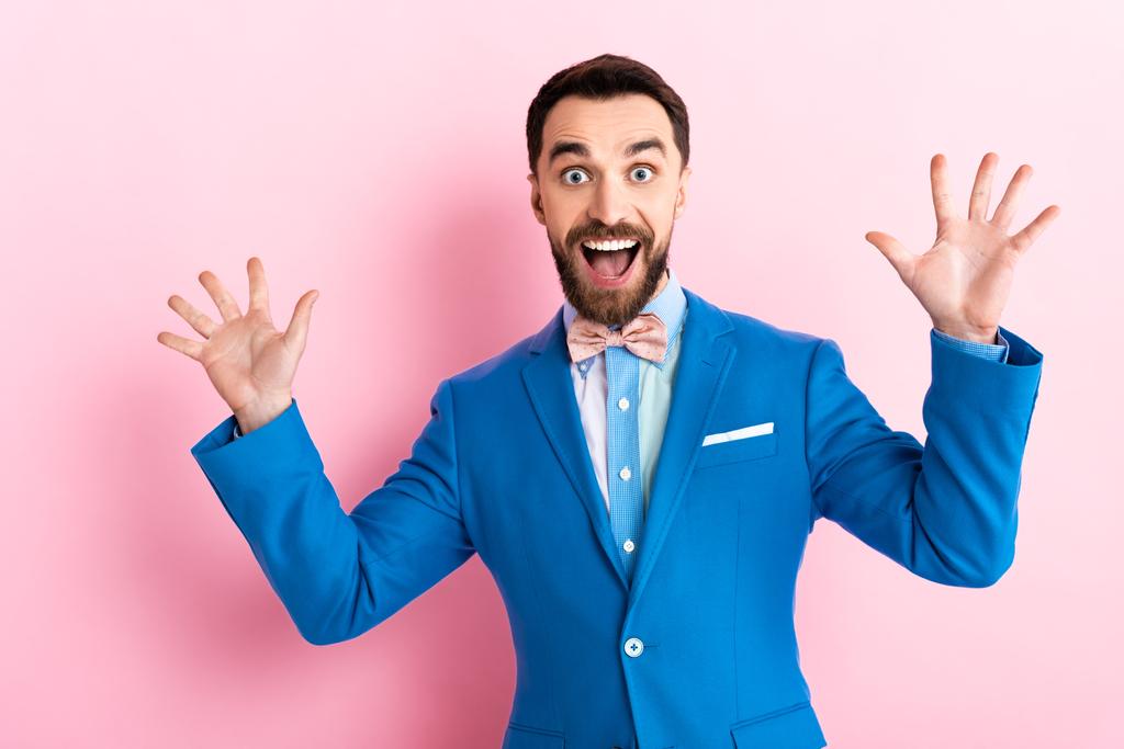 excited bearded businessman with opened mouth gesturing on pink  - Photo, Image