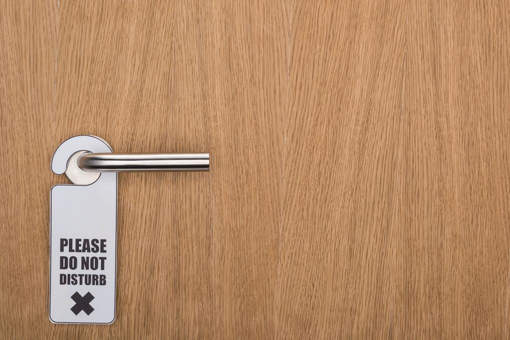 puerta de la habitación del hotel de madera con por favor no molestar signo en la manija
 - Foto, imagen