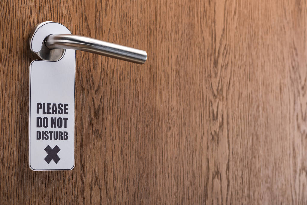 puerta de la habitación del hotel de madera con por favor no molestar signo en la manija
 - Foto, imagen