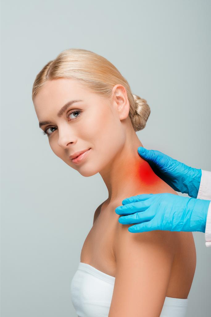 levágott kilátás orvos kék latex kesztyű érintő nő nyak piros jel elszigetelt szürke  - Fotó, kép
