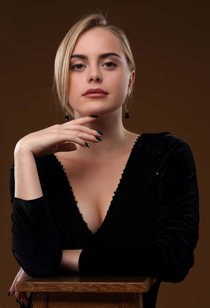 blondes Mädchen in einem schwarzen Kleid mit tiefem Ausschnitt - Foto, Bild