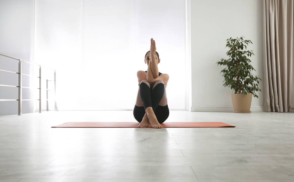 Femme pratiquant l'aigle asana dans un studio de yoga. pose Garudasana
 - Photo, image